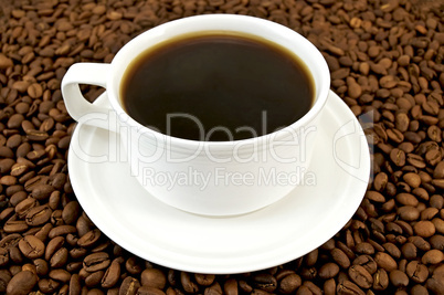 Coffee in white cup on coffee beans