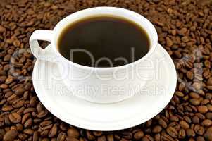 Coffee in white cup on coffee beans