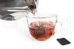 Tea from a bag in a glass cup with a teapot