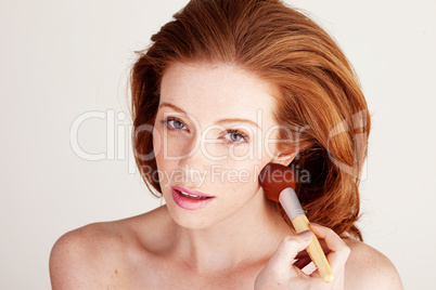 Woman Applying Blusher To Her Cheek