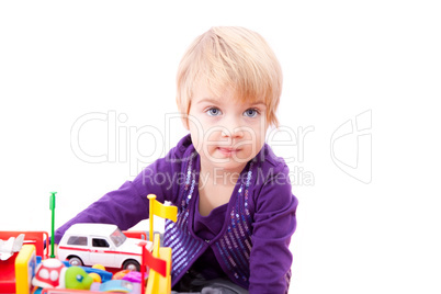 Cheerful little girl playing with toys