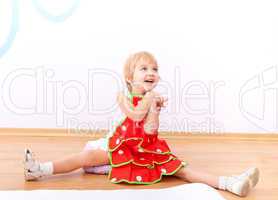 Cheerful little girl in red apron