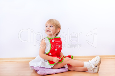 Cheerful little girl in red apron