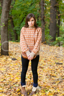 Young girl with handbag standing in the forest