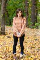 Young girl with handbag standing in the forest