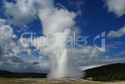 Old Faithful Geysir, blue sky and clouds, Yellowstone, Wyoming