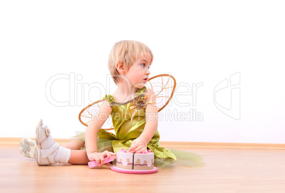 Cheerful fairy little girl cutting toy cake