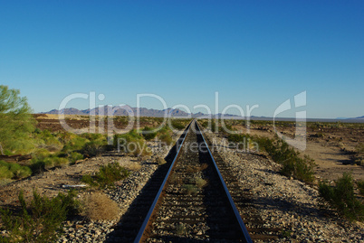 Railway track through vastness and emptiness of California desert