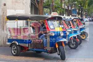 Line of tuktuks with driver on Bangkok street