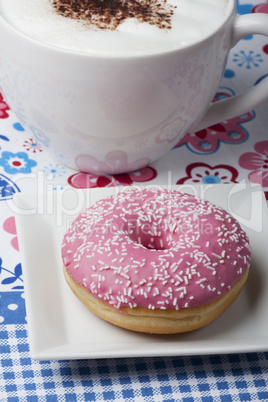 Rosa Donut und eine Tasse Cappuccino