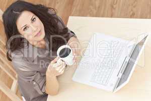Woman Using Laptop Computer At Home Drinking Tea or Coffee