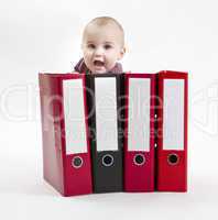 young child hiding behind ring file