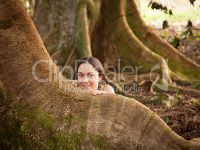 Girl peeping from behind Moreton Fig