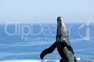 Statue of whale breaching with sea