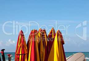 Tied up beach umbrellas by seaside