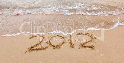 2012 written in sand with waves
