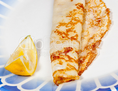 Pancake with lemon on blue plate