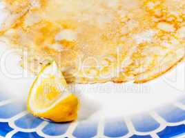 Pancake with lemon on blue plate