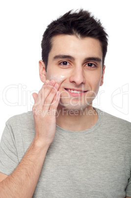 Young man applying cream lotion