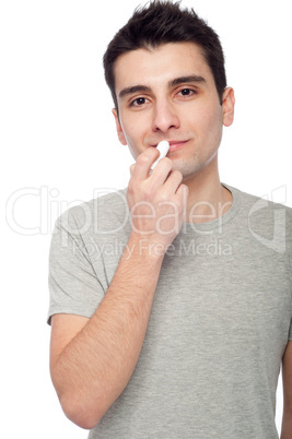 Young man applying lip balm
