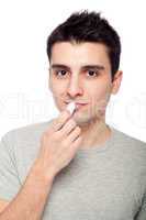 Young man applying lip balm