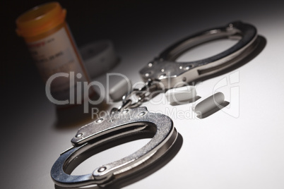 Handcuffs, Medicine Bottle and Pills Under Spot Light