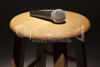 Microphone Laying on Wooden Stool Under Spotlight