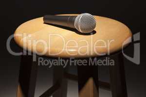 Microphone Laying on Wooden Stool Under Spotlight
