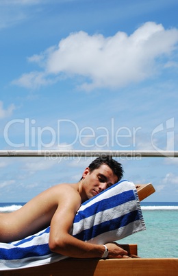 Young man sunbathing in a Maldives resort room
