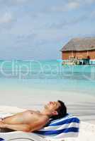 Young man sunbathing in a Maldivian Island beach