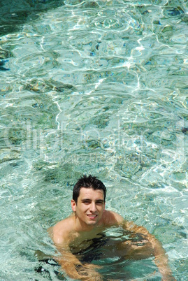 Young man relaxing and smiling in Maldives (ocean background)