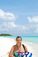 Beautiful senior woman walking on a tropical beach