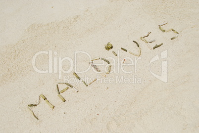 Maldives written in a sandy tropical beach