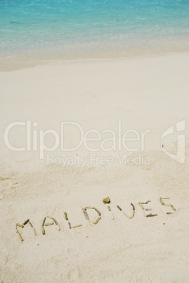 Maldives written in a sandy tropical beach