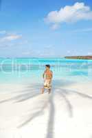 Young man standing on a tropical beach in Maldives