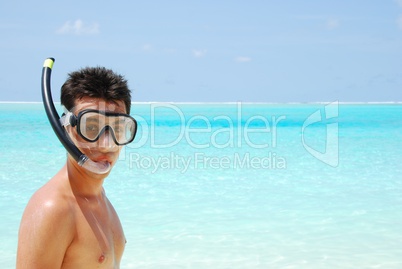 Young man ready to go snorkeling (blue ocean background)