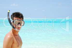 Young man ready to go snorkeling (blue ocean background)