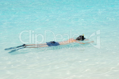 Young man snorkeling in Maldives (blue ocean water)