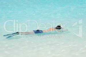 Young man snorkeling in Maldives (blue ocean water)