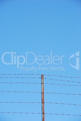 Barbed wire on blue sky background