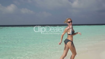 woman in bikini running on beach