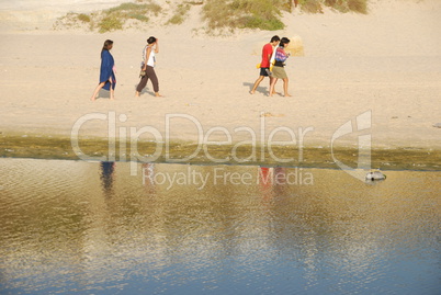 Young brothers/sisters walking on beach Young brothers/sisters walking on beach