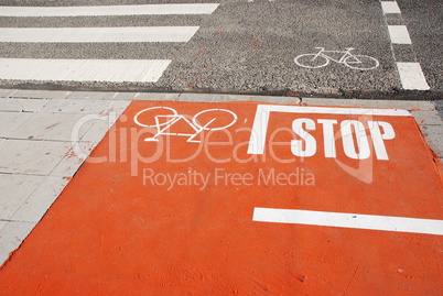 Orange bicycle lane with a STOP sign