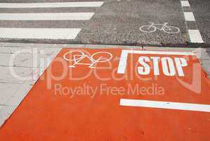 Orange bicycle lane with a STOP sign