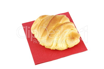 One fresh croissant on a red napkin