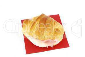 Cheese and ham croissant on a red napkin