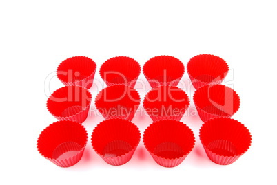 Red plastic cups for small cakes on white