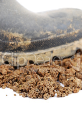 Black rubber boot and soil on white (close-up)