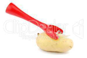 Peeling a potato with peeler on white