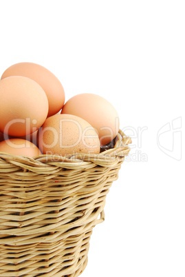 Close-up of eggs in a wicker basket on white